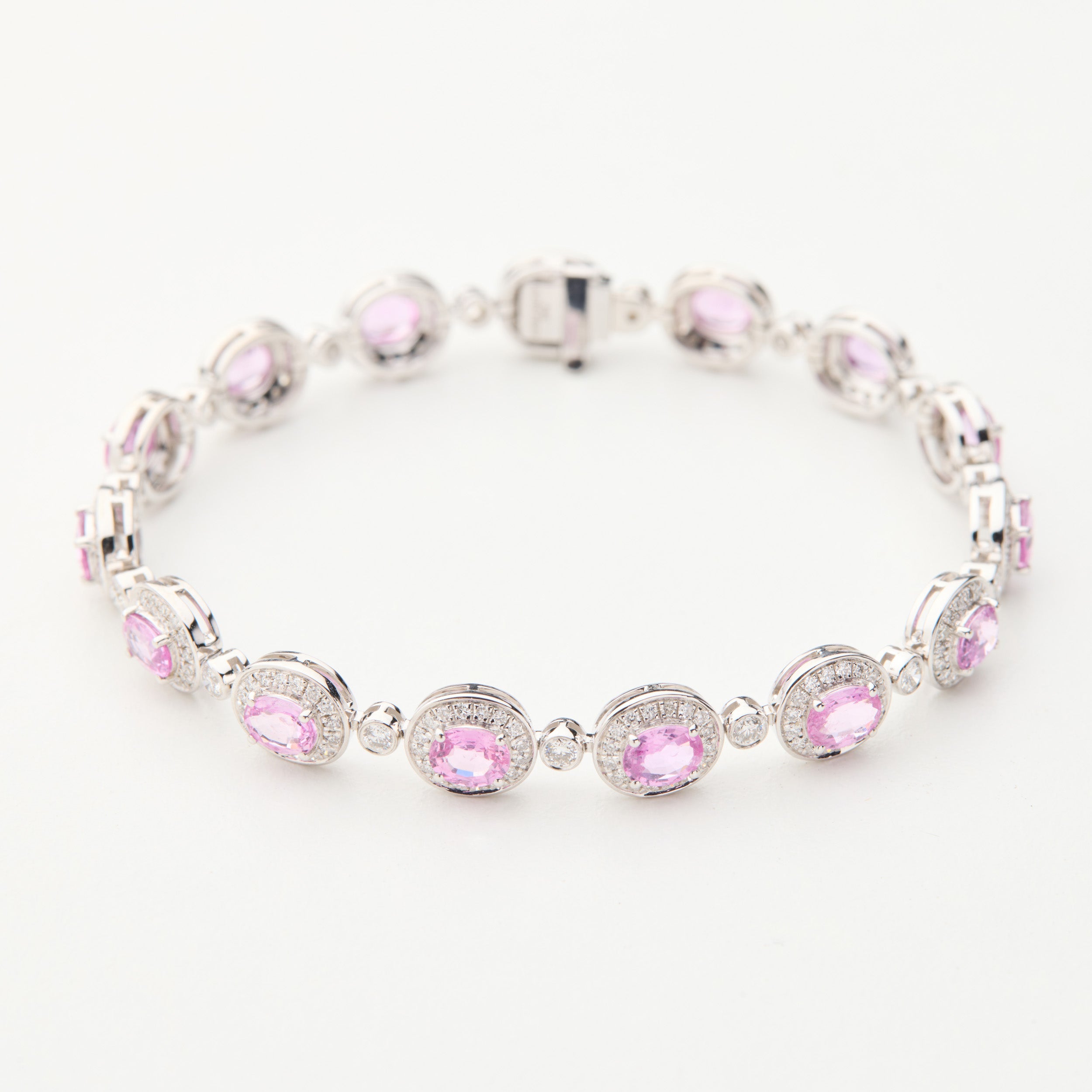 Aura Field bracelet with oval Padparadscha pink sapphires and diamond halos in 18K white gold